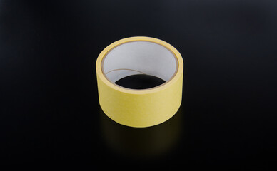 yellow masking tape roll on black background