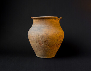 Old clay pot isolated on black background. Ceramic or clay jar