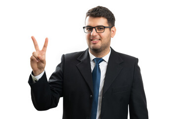 Smiling businessman in formalwear showing peace or victory sign