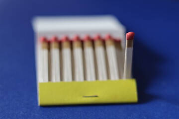 Una caja con varios fósforos o cerrillas  en un fondo azul