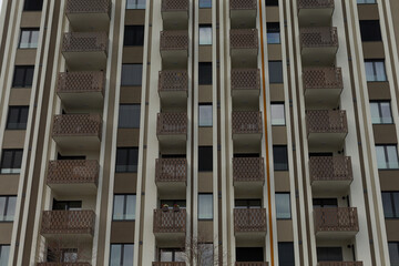 Fototapeta premium The facade of a contemporary apartment building features numerous balconies and large windows for residents