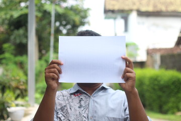 A young man's face was covered with blank white paper