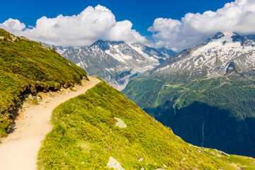 Tour du Mont Blanc beautiful landscapes in the Alps mountains on a sunny summer day. Green grass on...