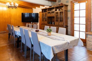 Large dining table with modern chairs and a rustic hutch in a home interior design setting, perfect for family gatherings