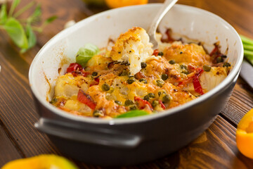 cauliflower baked with sweet pepper and vegetables under cheese