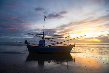 Naklejka premium sunset over the sea with fishing boat