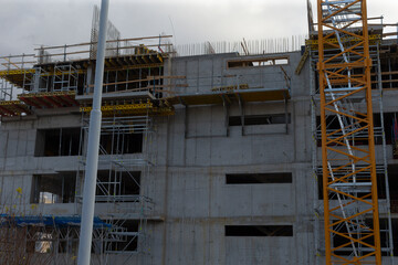 The building is under construction with scaffolding and a concrete background enhancing its structure