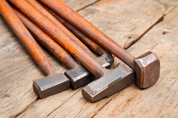 Classic Metalworking Tool Set Featuring Various Hammers on Wooden Background for Craftsmanship and DIY Projects