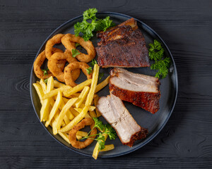 Baked pork ribs with onion rings and french fries
