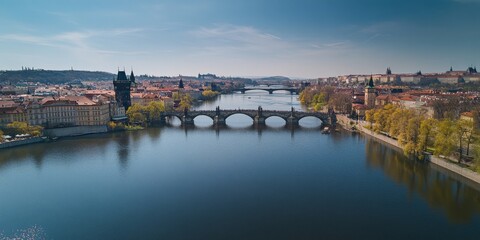 Fototapeta premium Prague's Old Town, seen from above in spring, shows the Charles Bridge arching over the Vltava River. The castle is visible in the distance.