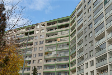 Two contemporary apartment buildings featuring attractive balconies situated against a clear blue sky