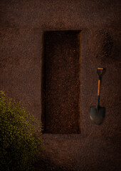 Freshly Dug Grave with Shovel and Soil, Surrounded by Greenery