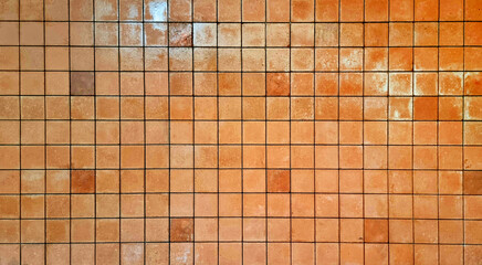 rustic terracotta tile mosaic with a grid pattern used as a background. perfect for vintage backgrounds and interior design. brown semi gloss brick tile background.