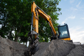 Yellow Excavator at Work in a Green Area - Front View