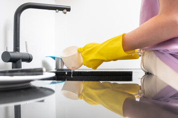 Close-up shot of a woman washing dishes in the kitchen. Household and cleaning concept	