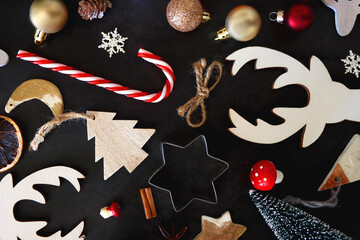 Various Christmas decorations in neutral colors on dark background. Top view.
