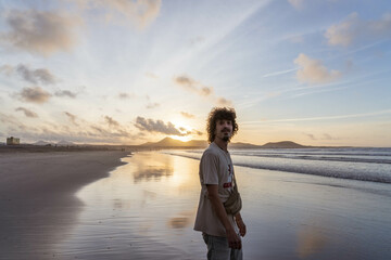 Chico disfrutando el atardecer en la Playa del Famara  (Lanzarote, Canarias)