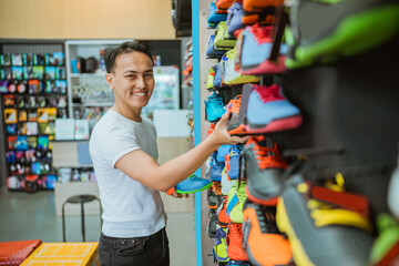 asian athletic footwear store staff arranging shoes in the display