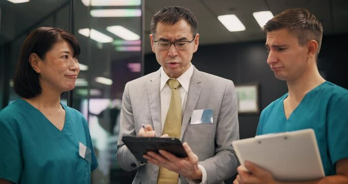 Hospital, nurses and health manager with tablet in meeting for staff management and healthcare service delivery. Medical admin, mature person or team with policy for quality assurance review in Japan
