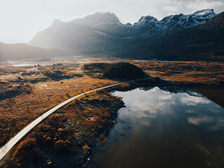 Experience the stunning aerial view of a breathtakingly serene landscape with majestic mountains
