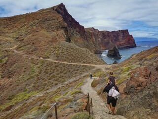 Hikers on a rugged trail along the dramatic cliffs of Ponta de São Lourenço, Madeira, with...