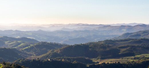 View of the hills of Montefeltro in Italy, from the Pietrarubbia region under the Carpegna Mount in the Italian Marche, close to Emilia Romagna and Toscana. Wind turbines appear in the background.