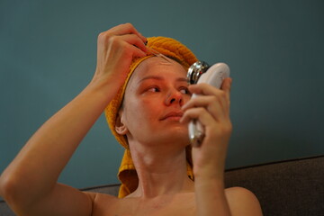 Young woman using infrared massager 