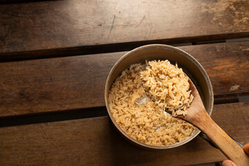 brown rice at the cooker on a wooden desk