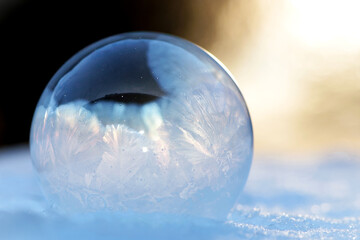 A frozen bubble in the snow. Beautiful frosty patterns on a frozen soap bubble. winter, frosty...
