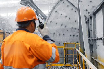 Metal manufacture factory concentrate of copper and gold. Professional heavy industry engineer worker control industrial ball mill grinds ore at mining and concentrating plant © Parilov