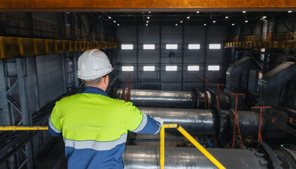 Engineer in uniform and protective helmet controls dryer industrial for iron, drying for magnetite...