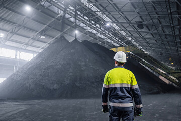 Industrial Worker on background large warehouse iron ore at factory