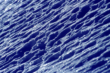 Artistic image made in velvia 50asa slide that portrays snow photographed against the sun that creates strong contrast effects with underexposed blue tones