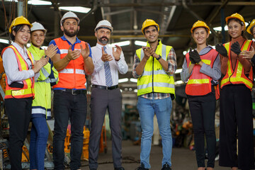 group of diversity engineer factory worker standing clapping hand celebrate job finished with businessman manager or executive boss leader team together in industry manufacturing warehouse.