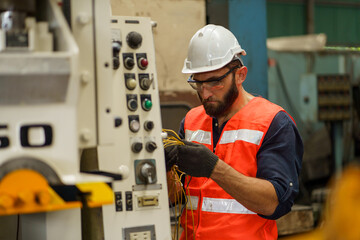 Electrician engineer checking electric cable wires in in electrical cabinet control of machine in...
