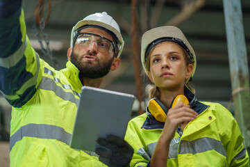 caucasian industrial Engineer manager man wearing eyeglass and helmet discussion with mechanic...