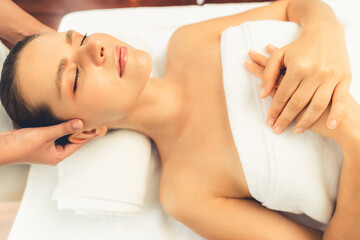Caucasian woman enjoying relaxing anti-stress head massage and pampering facial beauty skin recreation leisure in dayspa modern light ambient at luxury resort or hotel spa salon. Quiescent