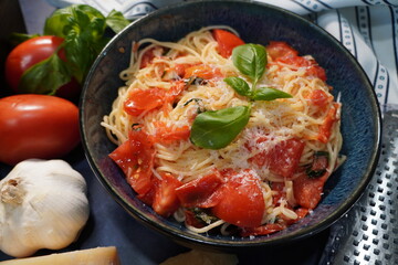 A classic Italian pasta dish, Capellini Pomodoro with fresh tomatoes, basil and garlic. Making an Italian meal for dinner using fresh ingredients from the garden.