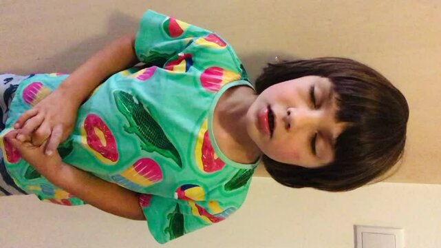 Long-haired boy with missing front baby teeth speaking to the camera, child showing an expression. Authentic Storytelling and user generated content. Vertical smartphone shot.