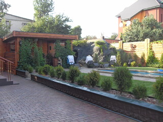 Backyard with wooden sauna, swimming pool, and decorative rock garden landscaping