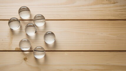 Clear edible water blobs on wooden table with ample text space