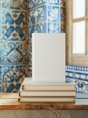 A stack of three white, gray and blue blank photo albums against a background of colorful tiles