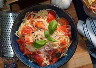 A classic Italian pasta dish, Capellini Pomodoro with fresh tomatoes, basil and garlic. Making an Italian meal for dinner using fresh ingredients from the garden.