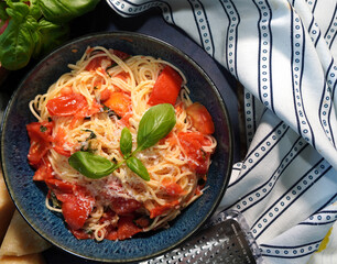 A classic Italian pasta dish, Capellini Pomodoro with fresh tomatoes, basil and garlic. Making an Italian meal for dinner using fresh ingredients from the garden.