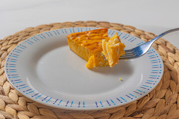 a piece of pumpkin pie on a plate that sits on an eco-friendly textured stand