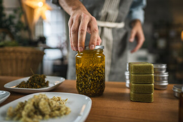Adult man herbalist prepare natural oils in a rustic kitchen setting
