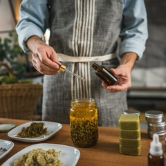 Adult man herbalist prepare natural oils in a rustic kitchen setting