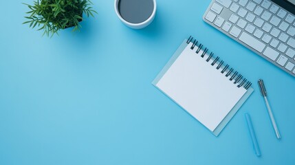 Notepad, mortarboard, and keyboard on a blue background for online education concepts. 