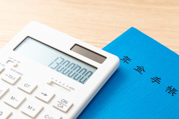 130万と表示された電卓と年金手帳