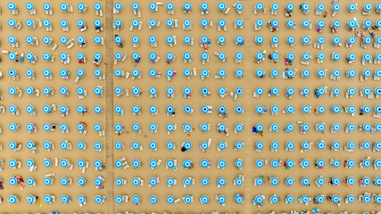 Aerial perpendicular view of a beach club on a large and crowded sandy beach. There are many people...